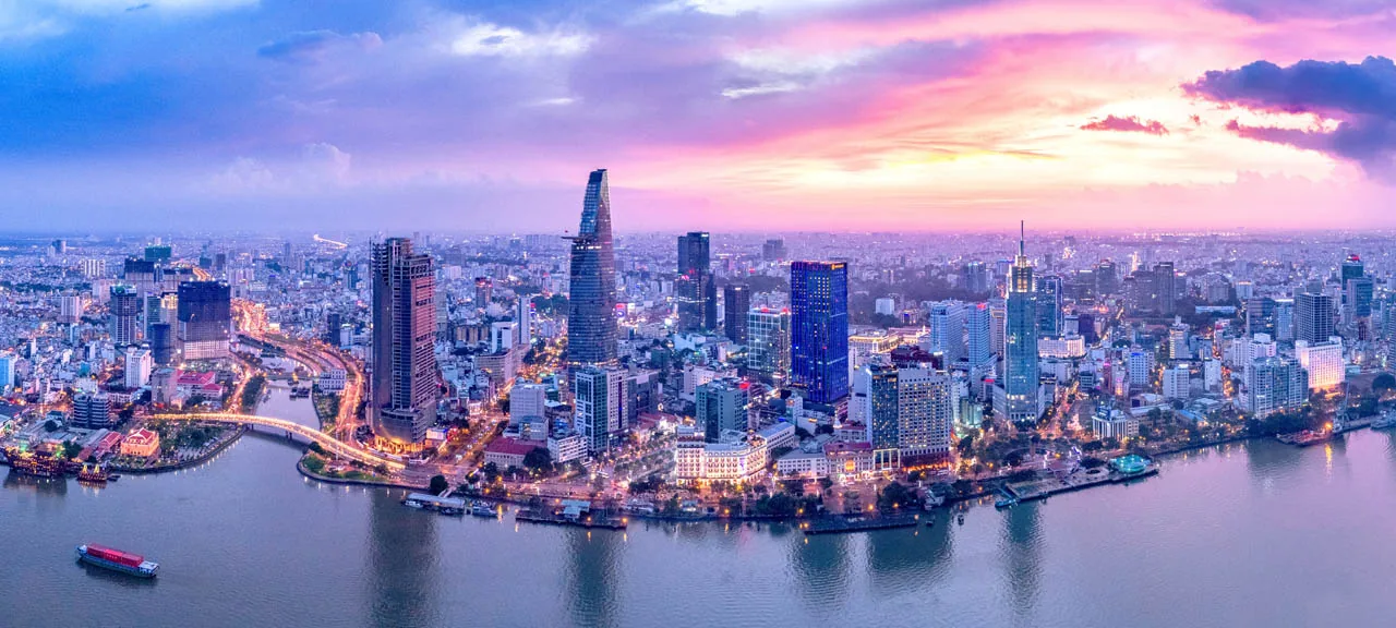 Ho Chi Minh City skyline at night with the Bitexco Tower reflected in the river