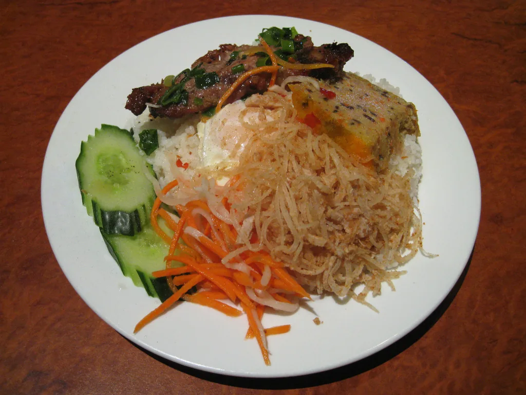 Com tam broken rice pork Vietnam — a Saigon institution served around the clock from street stalls and sit-down shops alike
